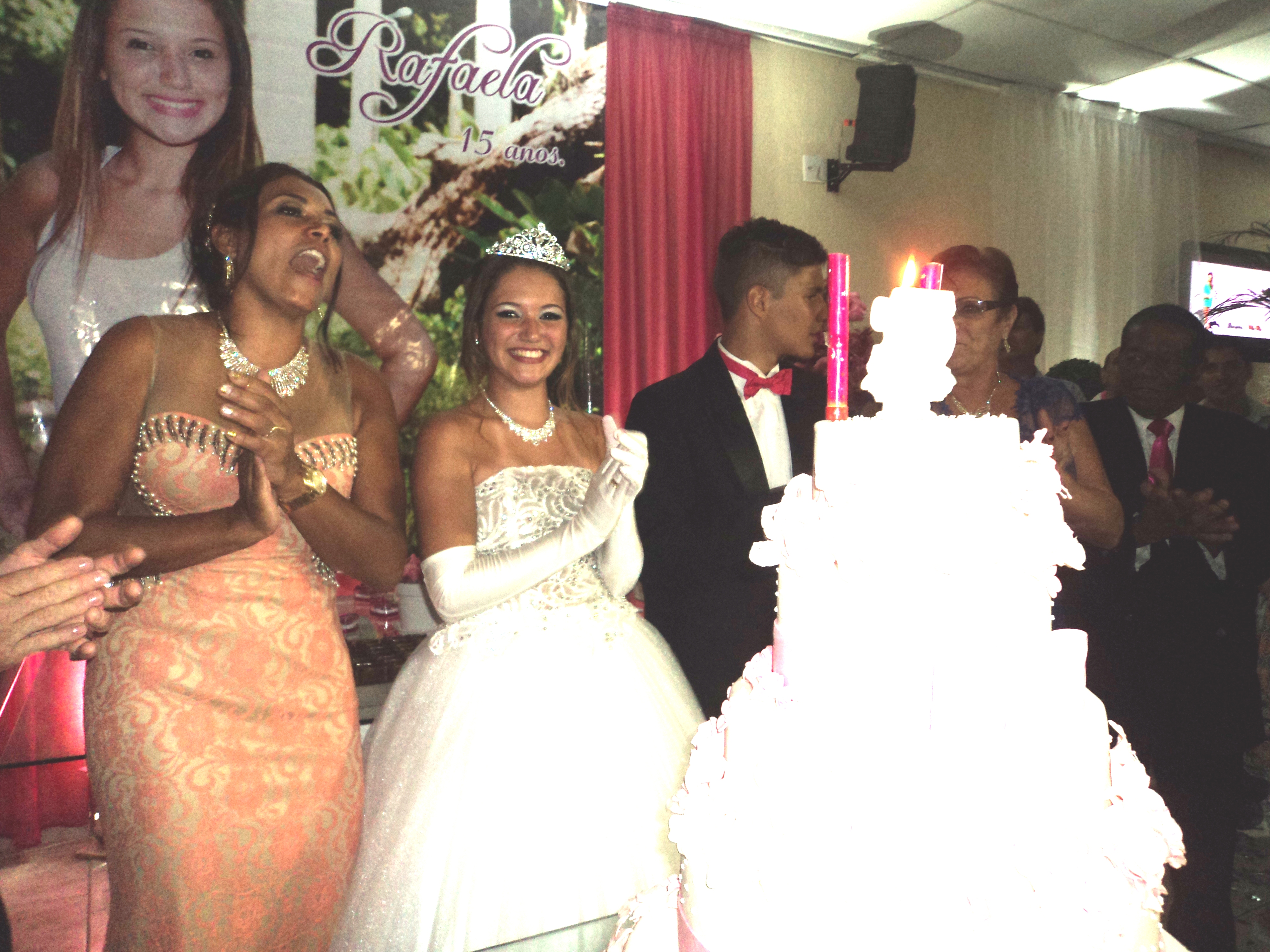 Rafaela, na hora do "parabéns para você" na mesa do bolo entre sua mãe e seu "príncipe".