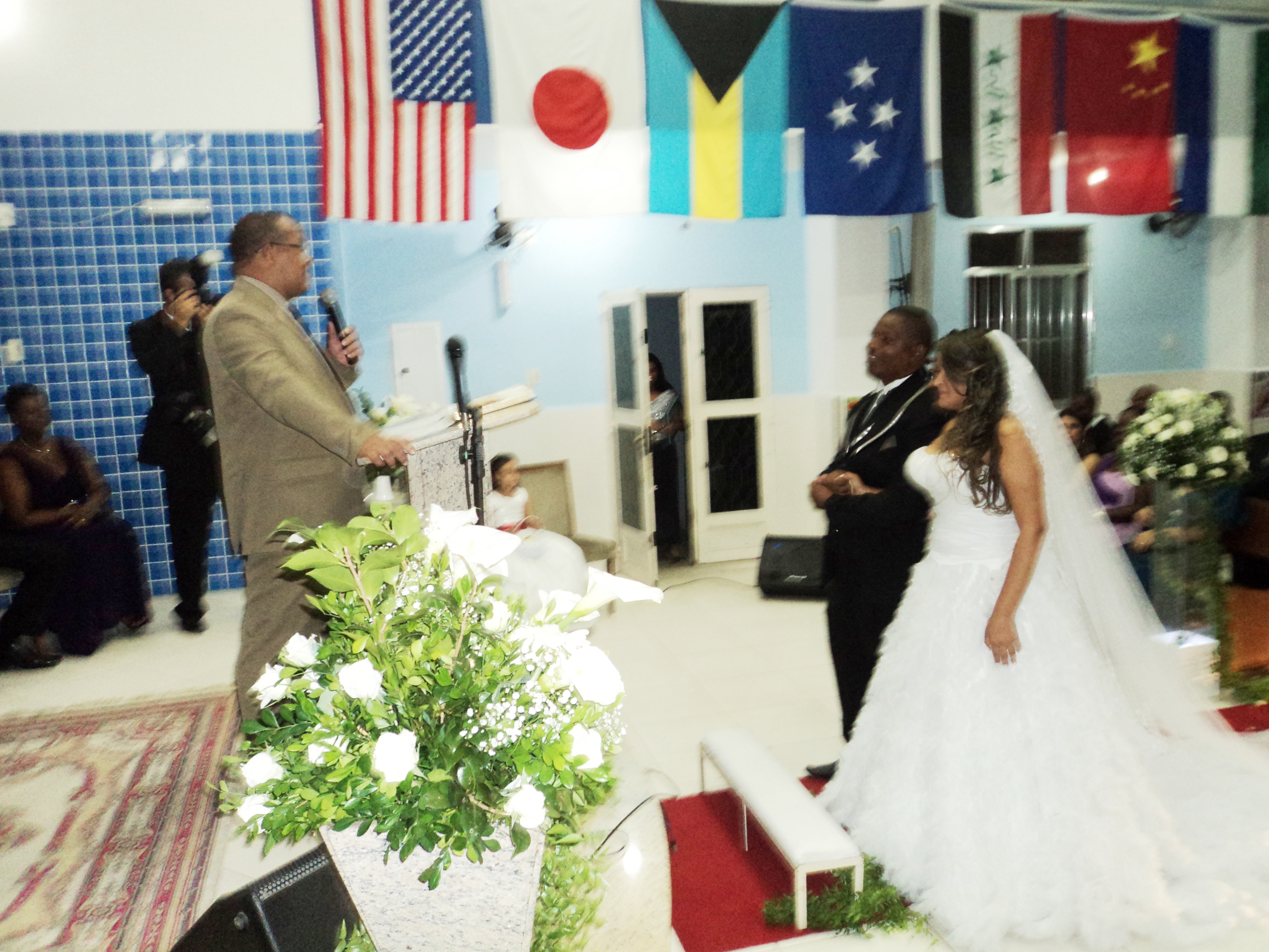 Os noivos Juliana e Paulo Junior na igreja com o pastor de celebrante.